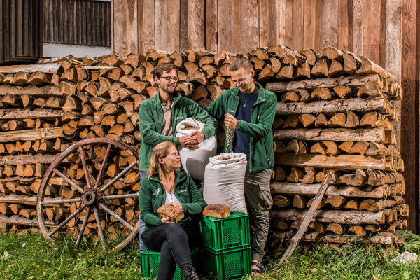 Silke, Paule und Constantin Lucht (Guidohof) vor Holzstapeln
